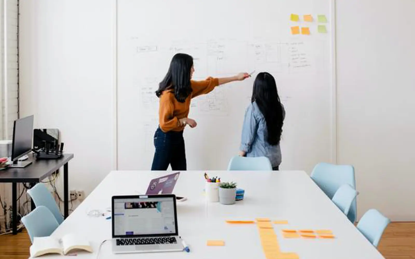 a woman pointing at a whiteboard