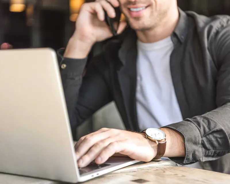 Man on phone and laptop using marketing personalisation