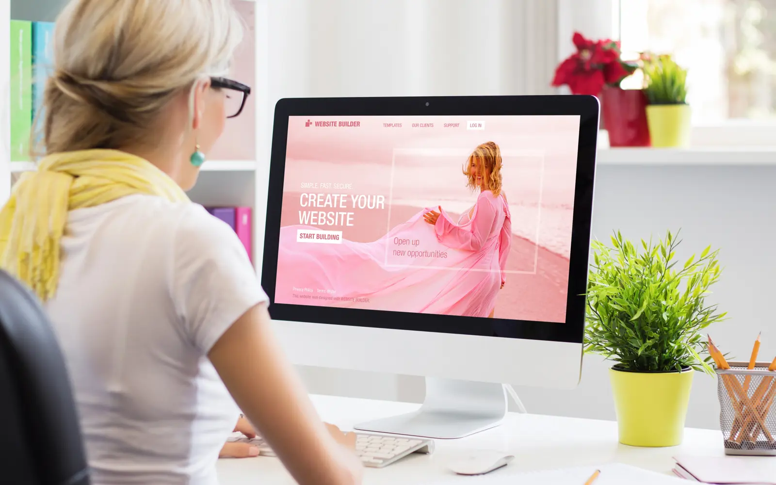 a woman sitting at a desk looking at a computer screen