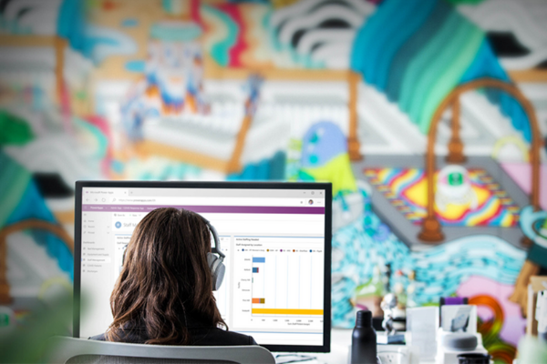 a woman wearing headphones looking at a computer screen