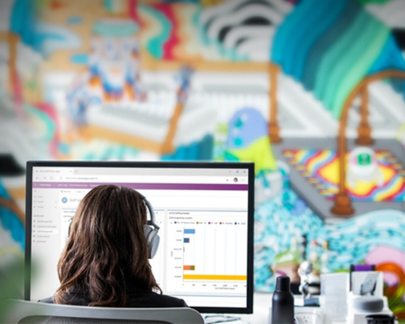 a woman wearing headphones looking at a computer screen