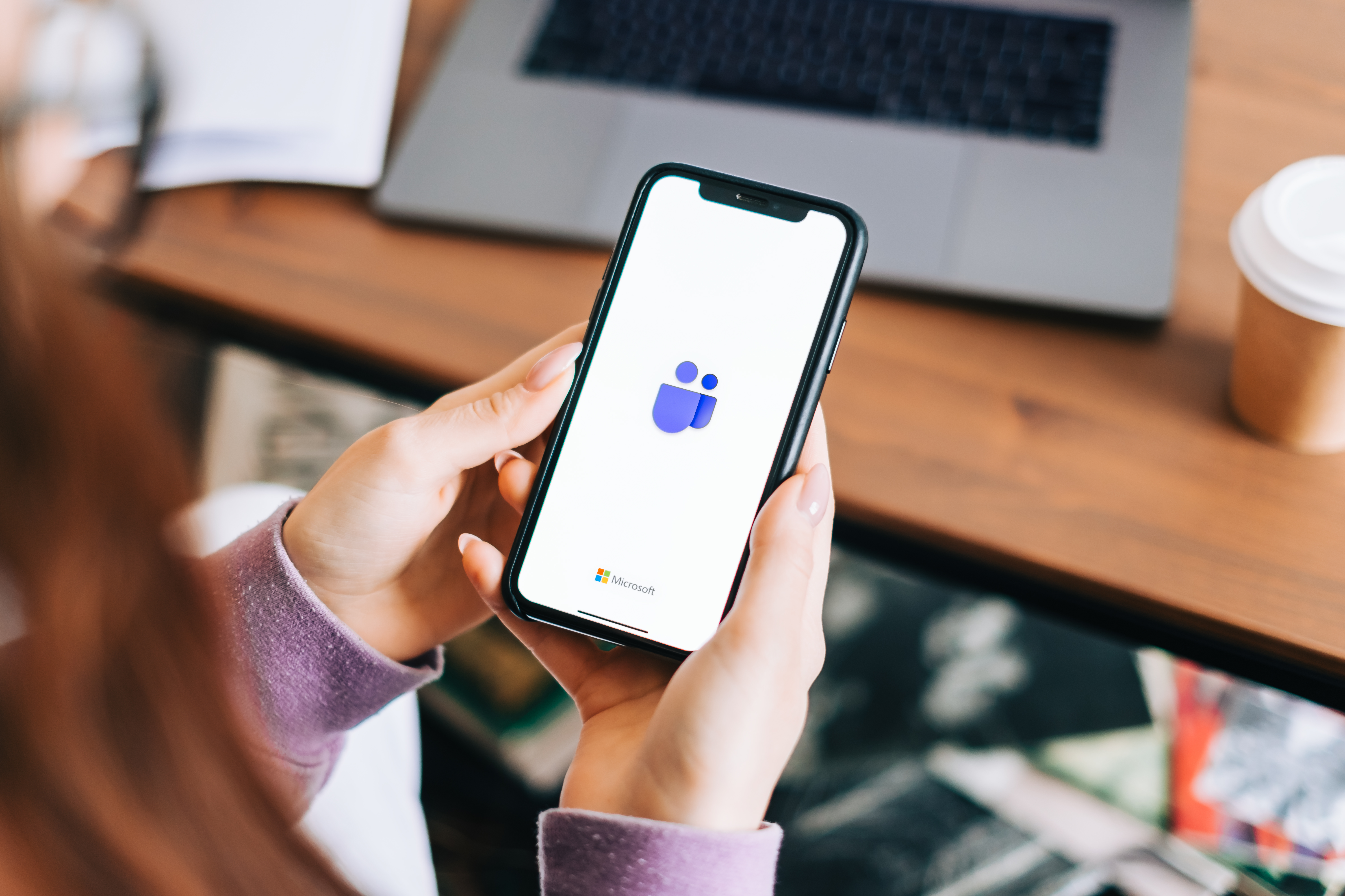 a person holding a phone using teams app