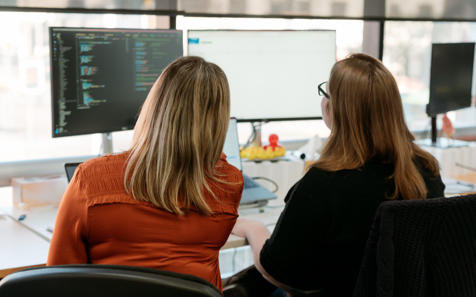 a group of women looking at a computer screen