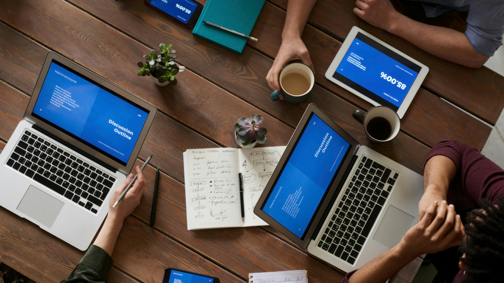a group of people working on laptops and tablets