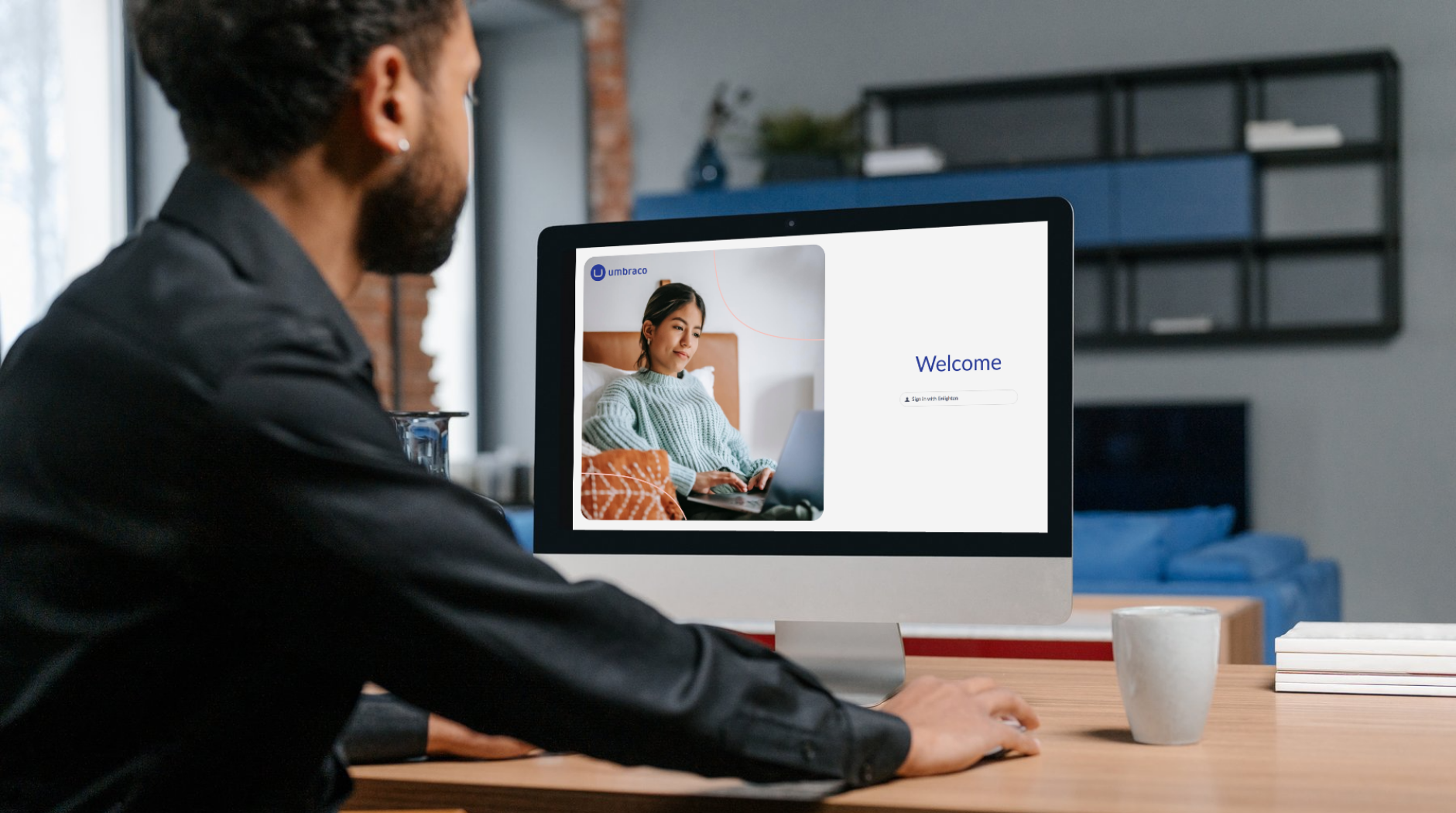 A man looking at a computer screen of Umbraco a Customer Management system.