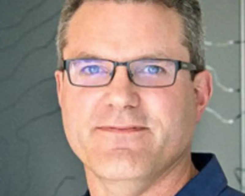 a man wearing glasses and a blue shirt