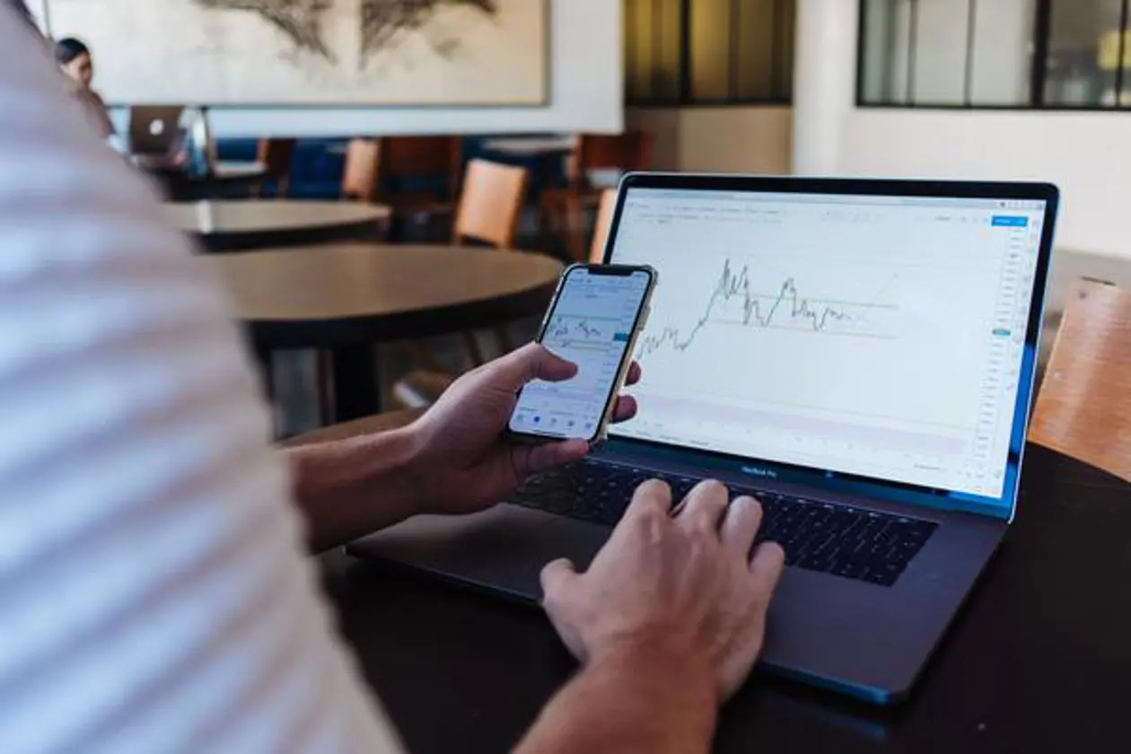 a person using a laptop and a phone